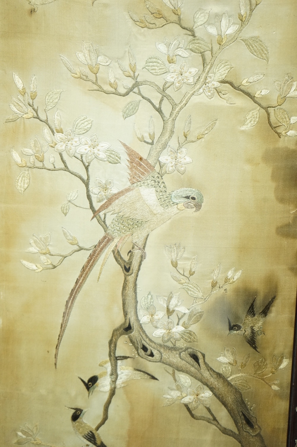 A pair of Chinese embroidered ‘Hundred Bird’ silkwork pictures, c. 1900, in Hongmu and mother-of-pearl inlaid frames, total size 99cm x 32cm. Condition - dark staining and tears to the silk, losses to the mother of pearl